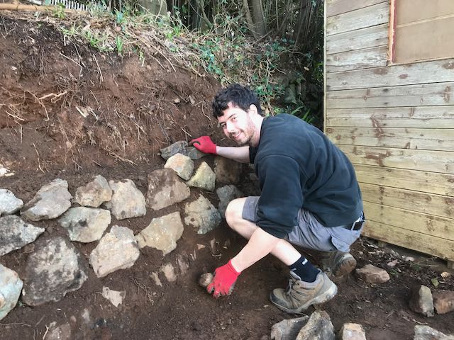 Sam building a stone wall 